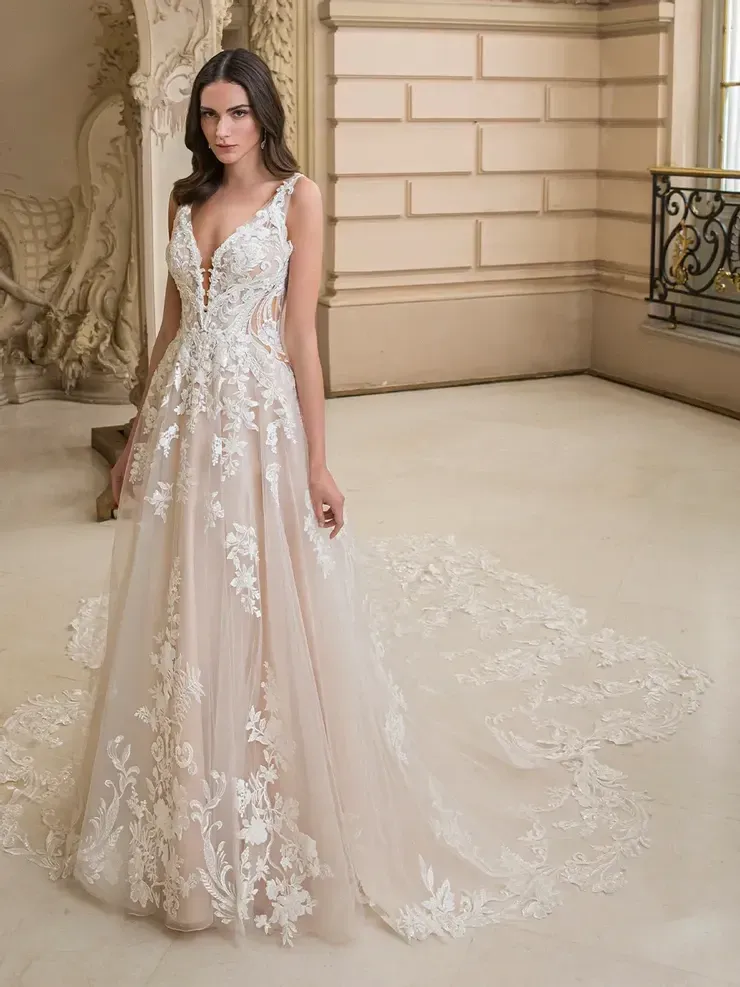 A woman is standing in a room wearing a wedding dress.
