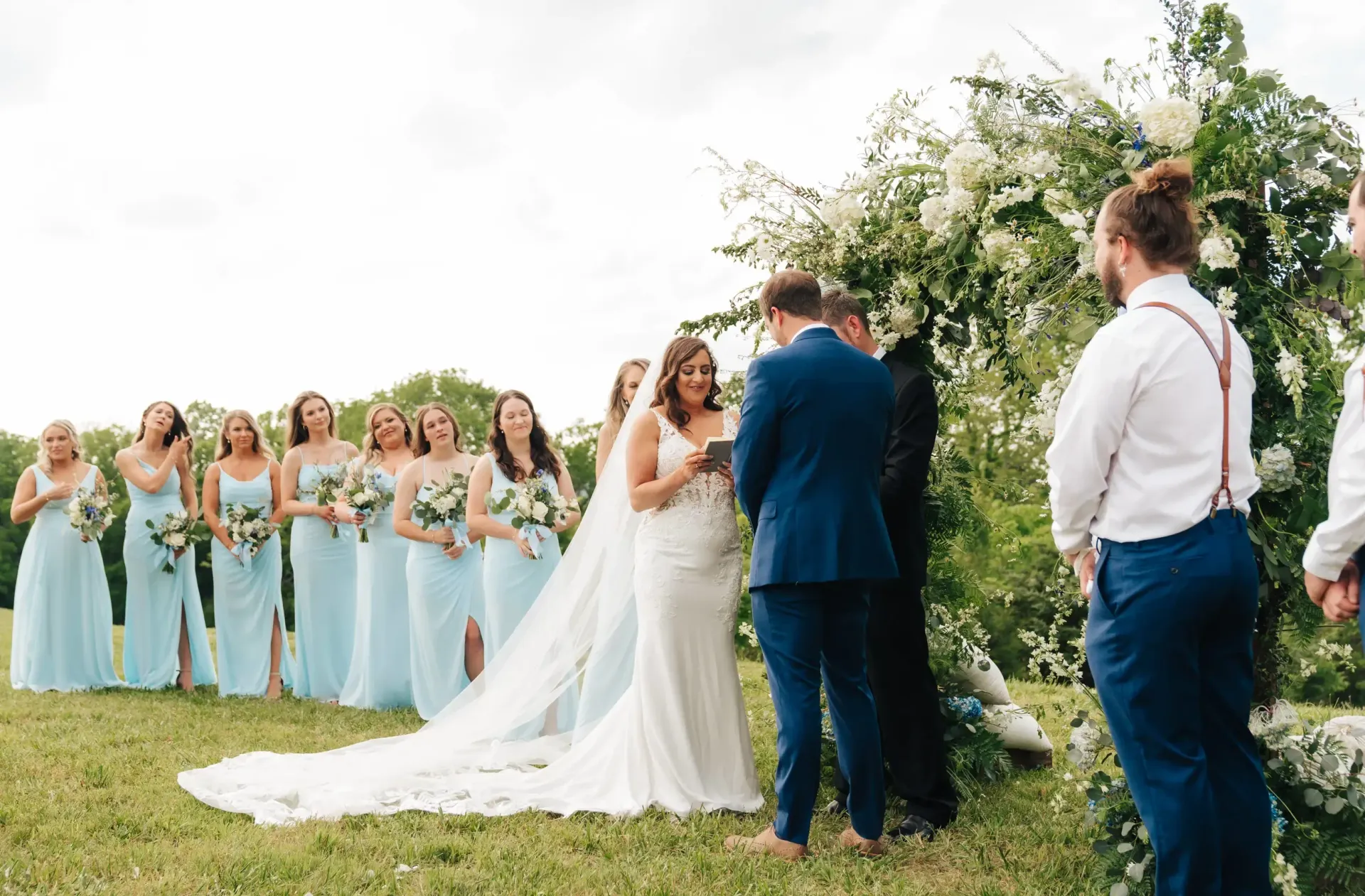 A bride and groom are getting married in front of their bridesmaids and groomsmen.