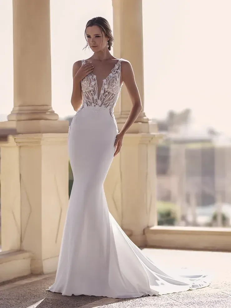 A woman in a white wedding dress is standing on a balcony.