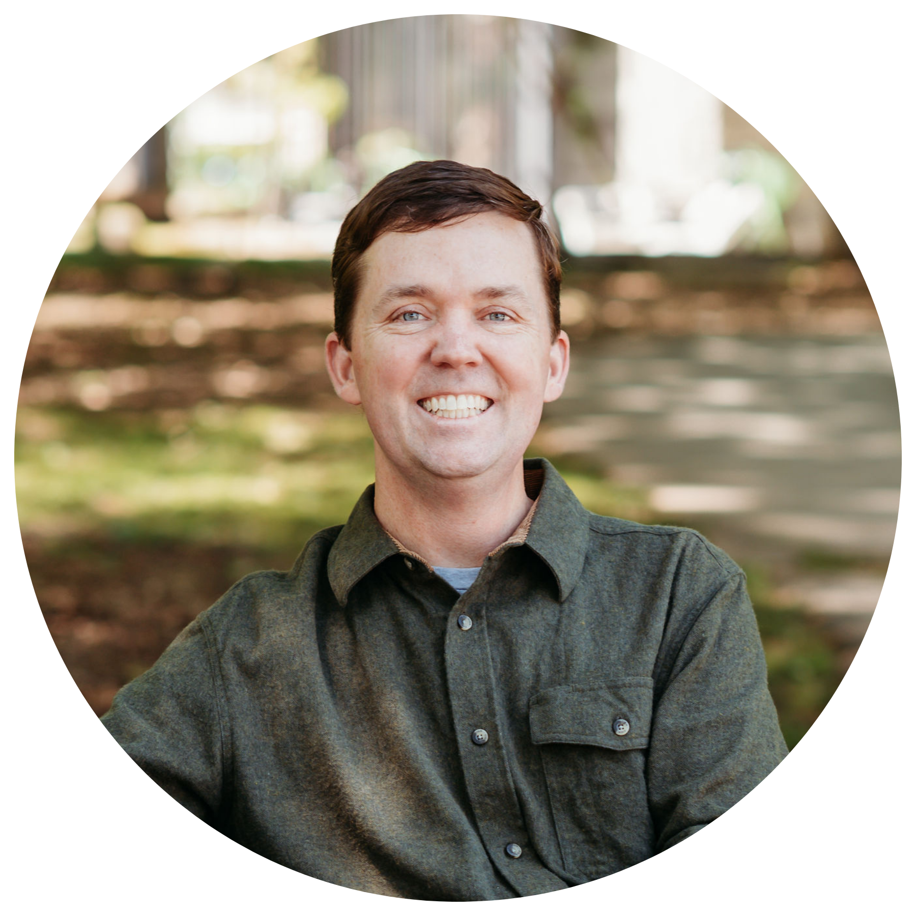 A man in a green shirt is smiling for the camera.