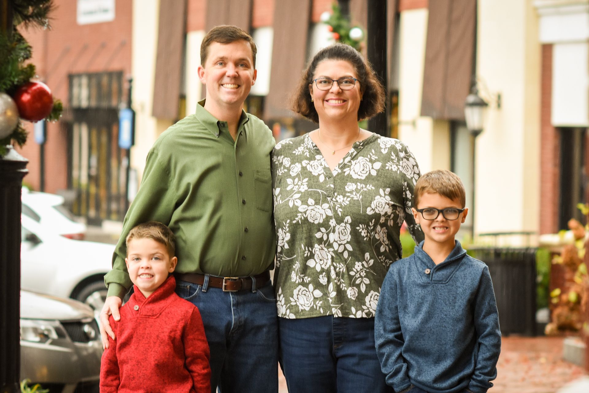A family is posing for a picture in front of a building.