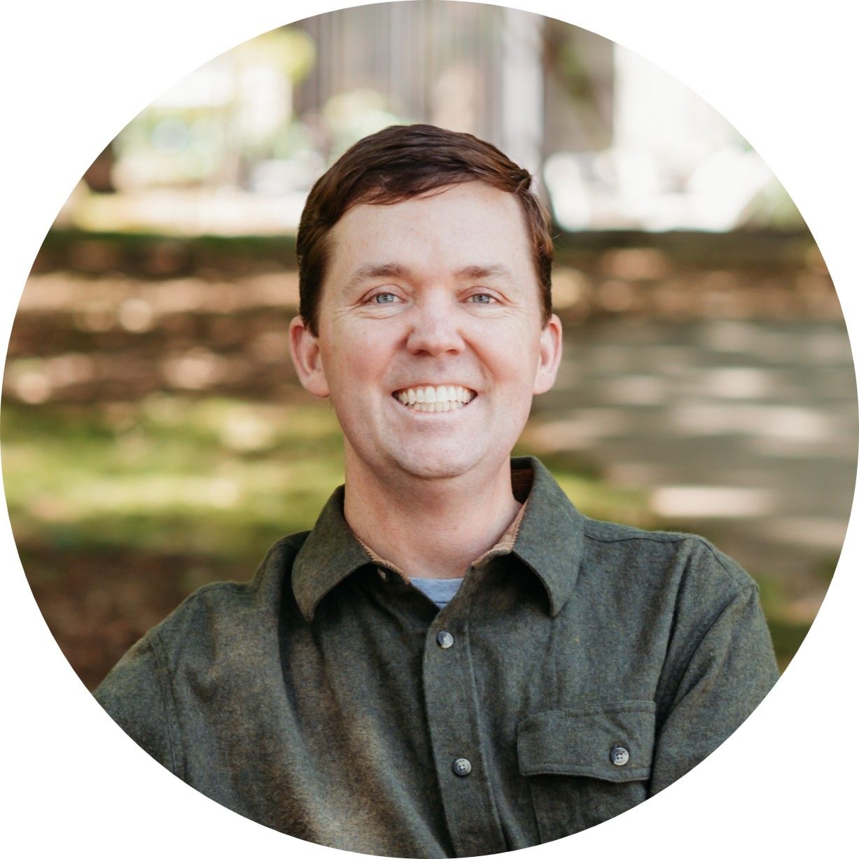 A man in a green shirt is smiling for the camera.
