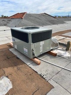 A large air conditioner is sitting on top of a roof.