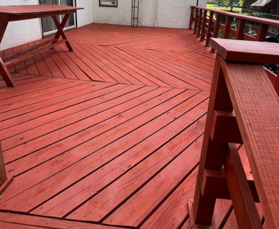A red deck with a table and chairs on it