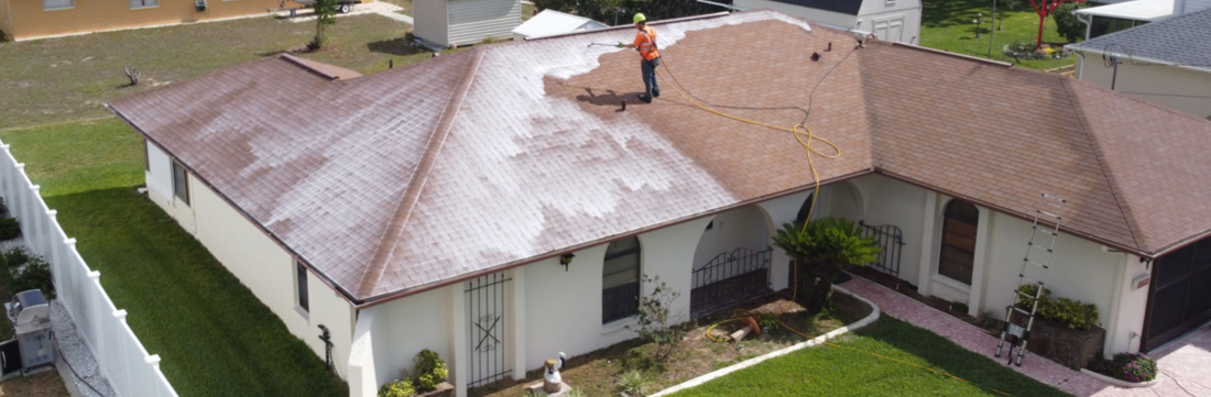An aerial view of a house with a man standing on the roof.