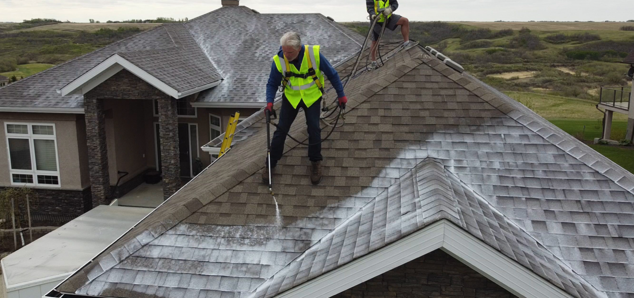 A man is standing on the roof of a house.