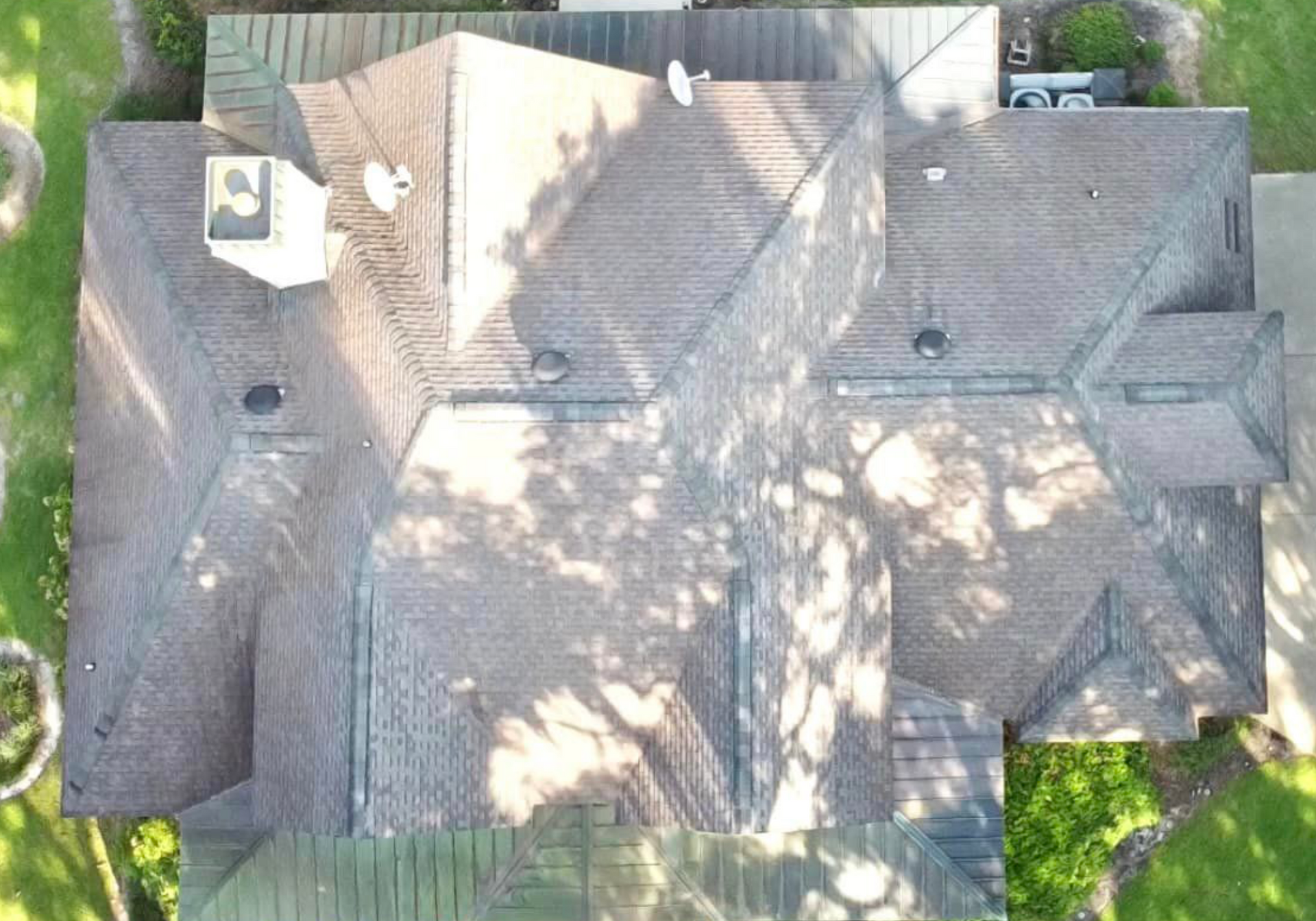 An aerial view of a large house with a roof that is covered in shingles.