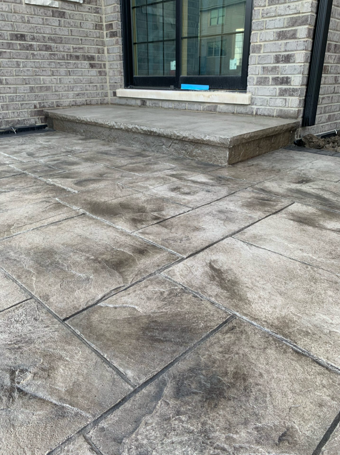 A brick building with a concrete patio in front of it.