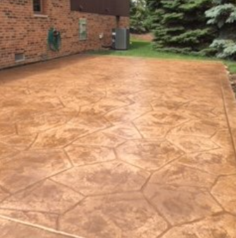 A brick house with a concrete driveway in front of it.