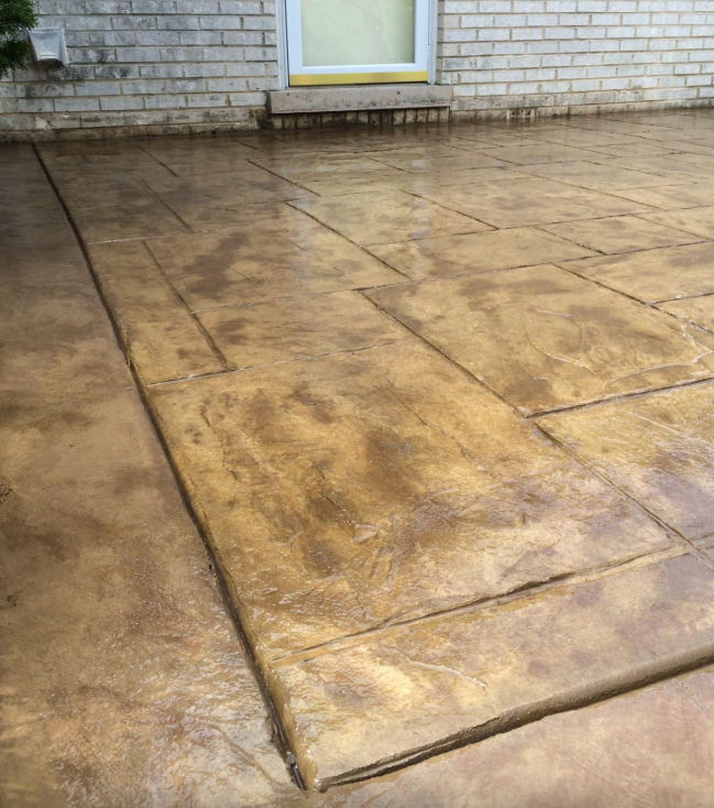 A close up of a concrete patio in front of a brick building.