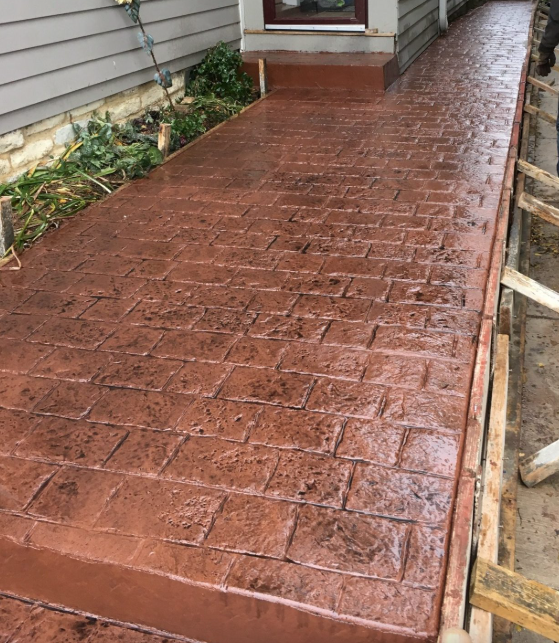 A brick walkway is being built in front of a house.