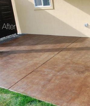 A patio with a stained concrete floor in front of a house.