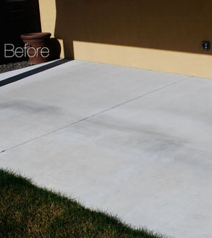 A before picture of a concrete driveway in front of a house