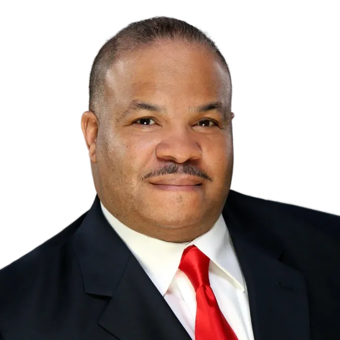 Headshot of a man in a dark suit, white shirt, and red tie against a white background