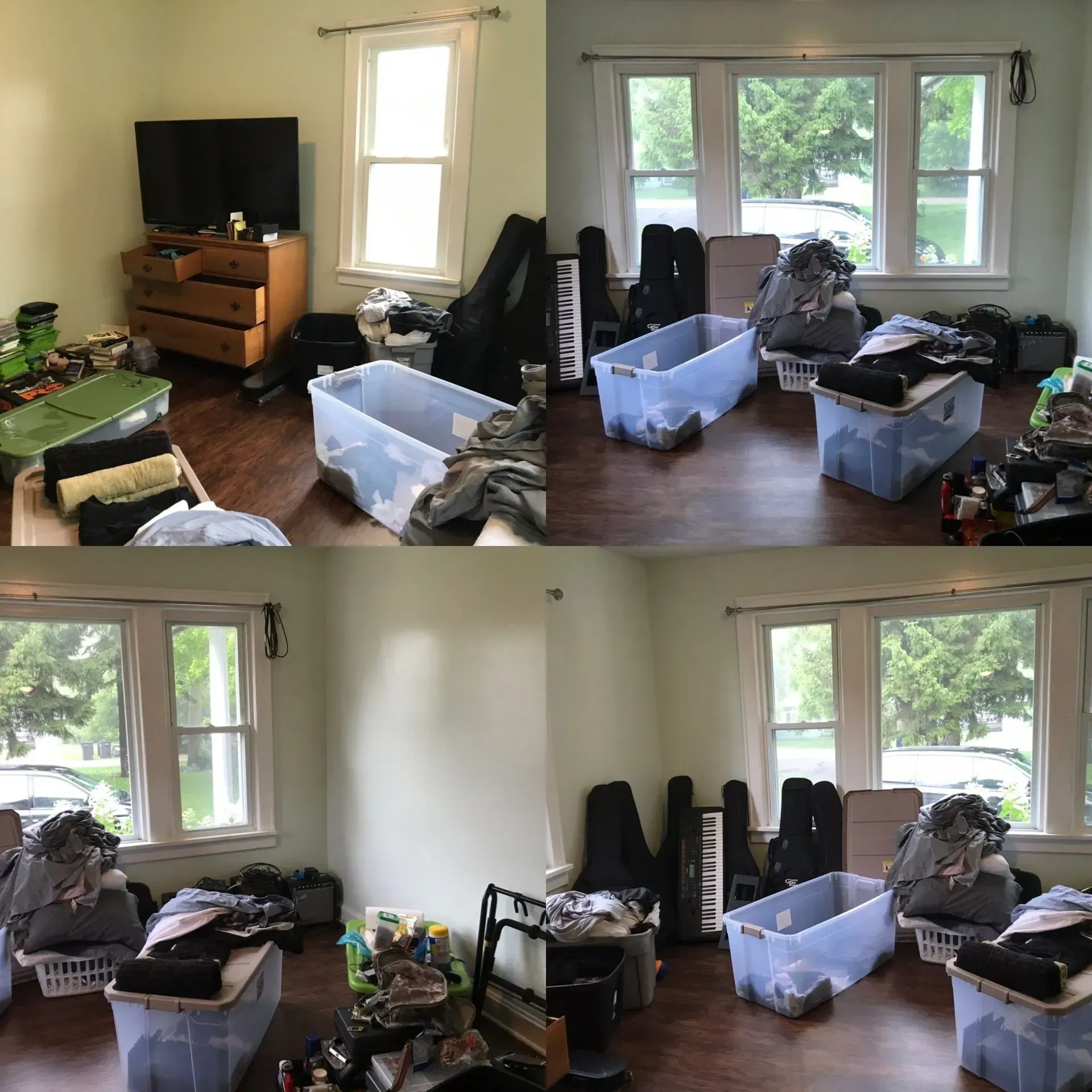 Cluttered living room with storage bins, open suitcases, and clothing spread across the floor by windows