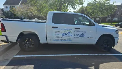 White pickup truck with black wheels parked; text on side says 