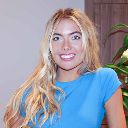 A woman in a blue shirt is smiling for the camera
