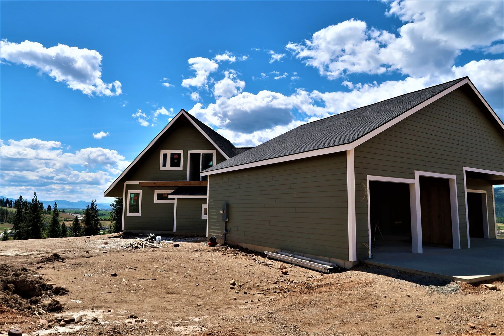 New suburban house with detached garage under a bright blue sky