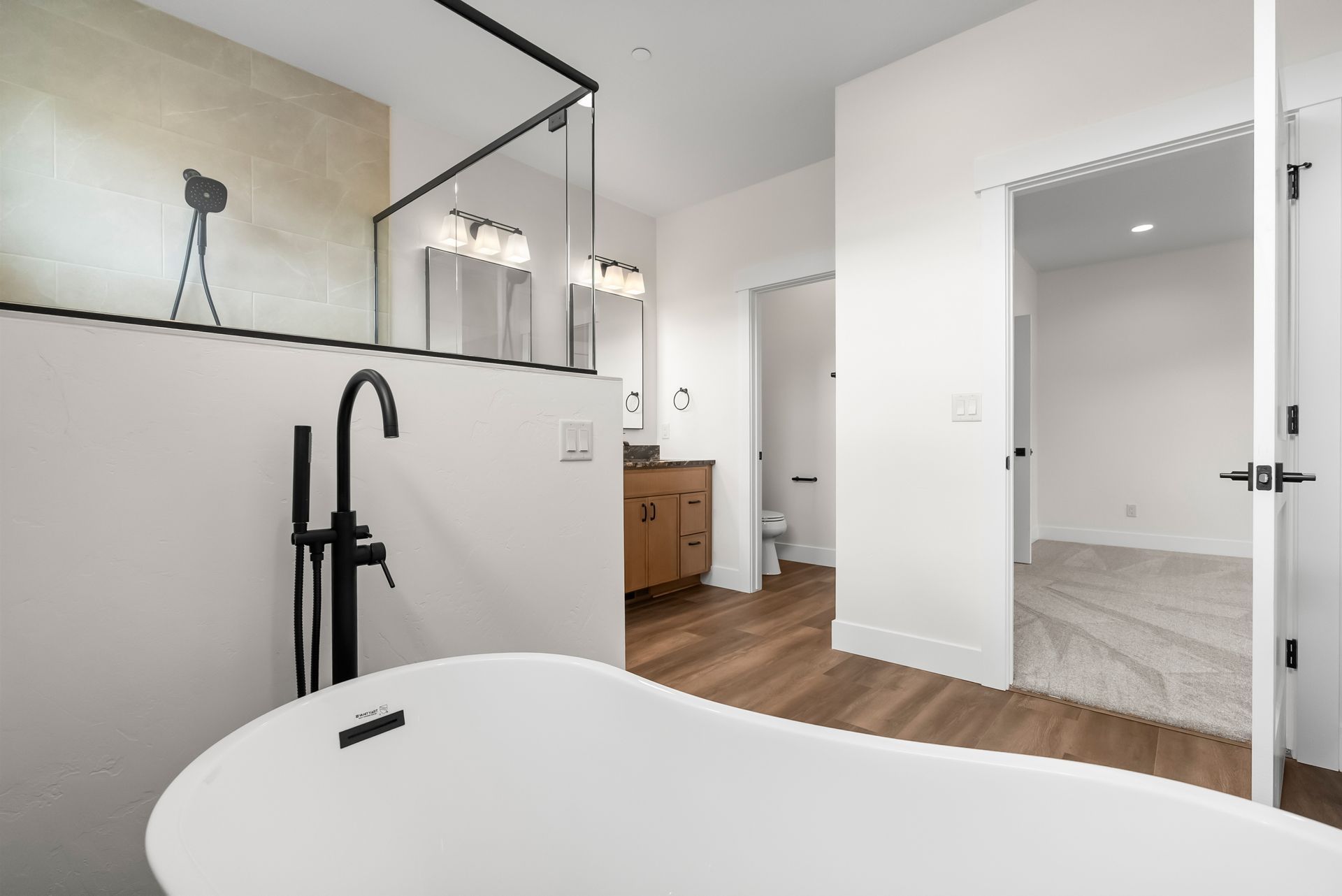 Bright modern bathroom with freestanding tub, black fixtures, and walk-in shower.