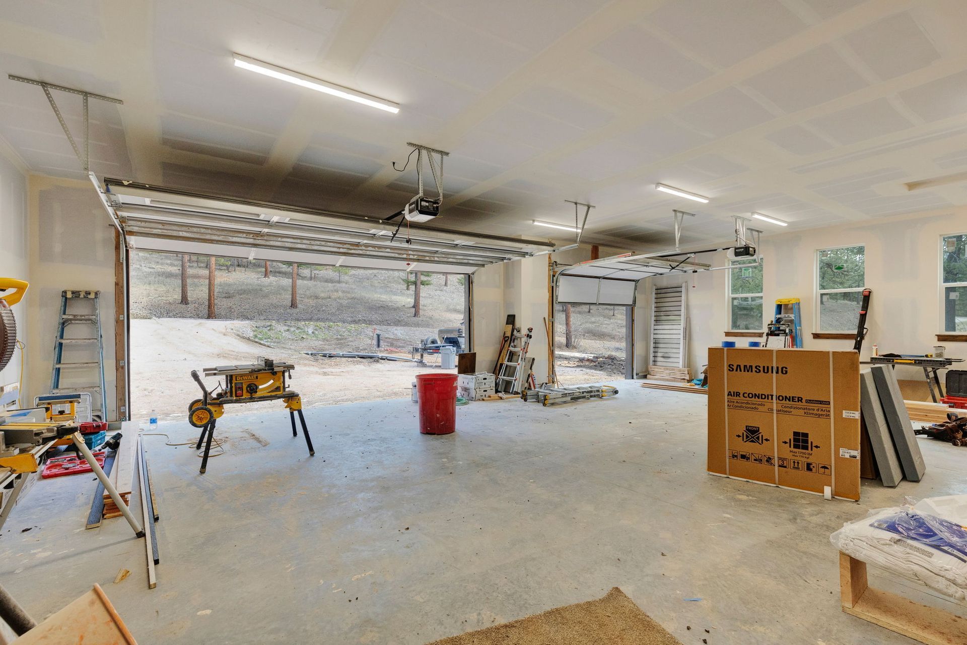 Renovated garage interior with exposed stone wall, workbench, tools, and construction materials.