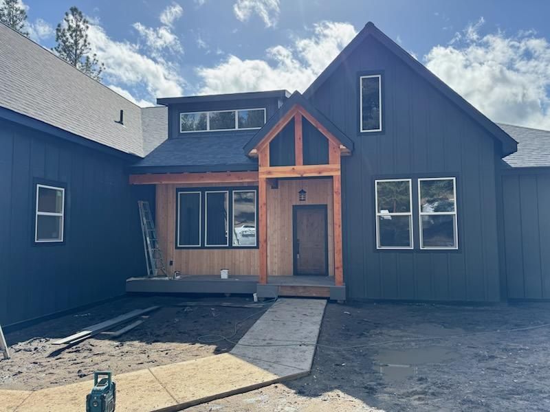Modern dark-blue house exterior with a front walkway and wood-trimmed entry