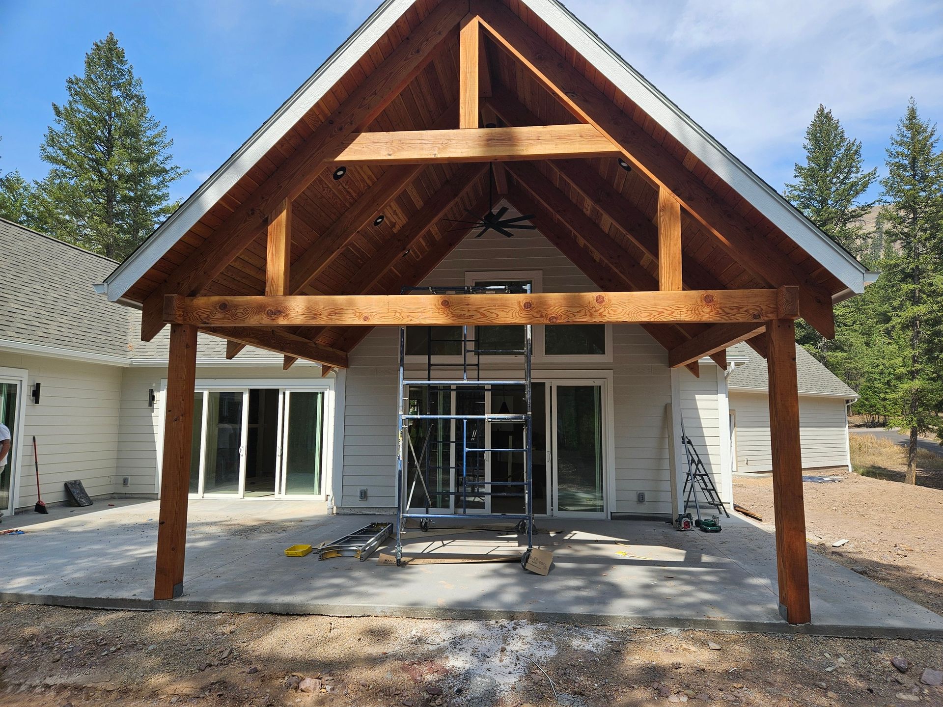Front porch under construction on a house, with exposed wood beams and unfinished entryway.