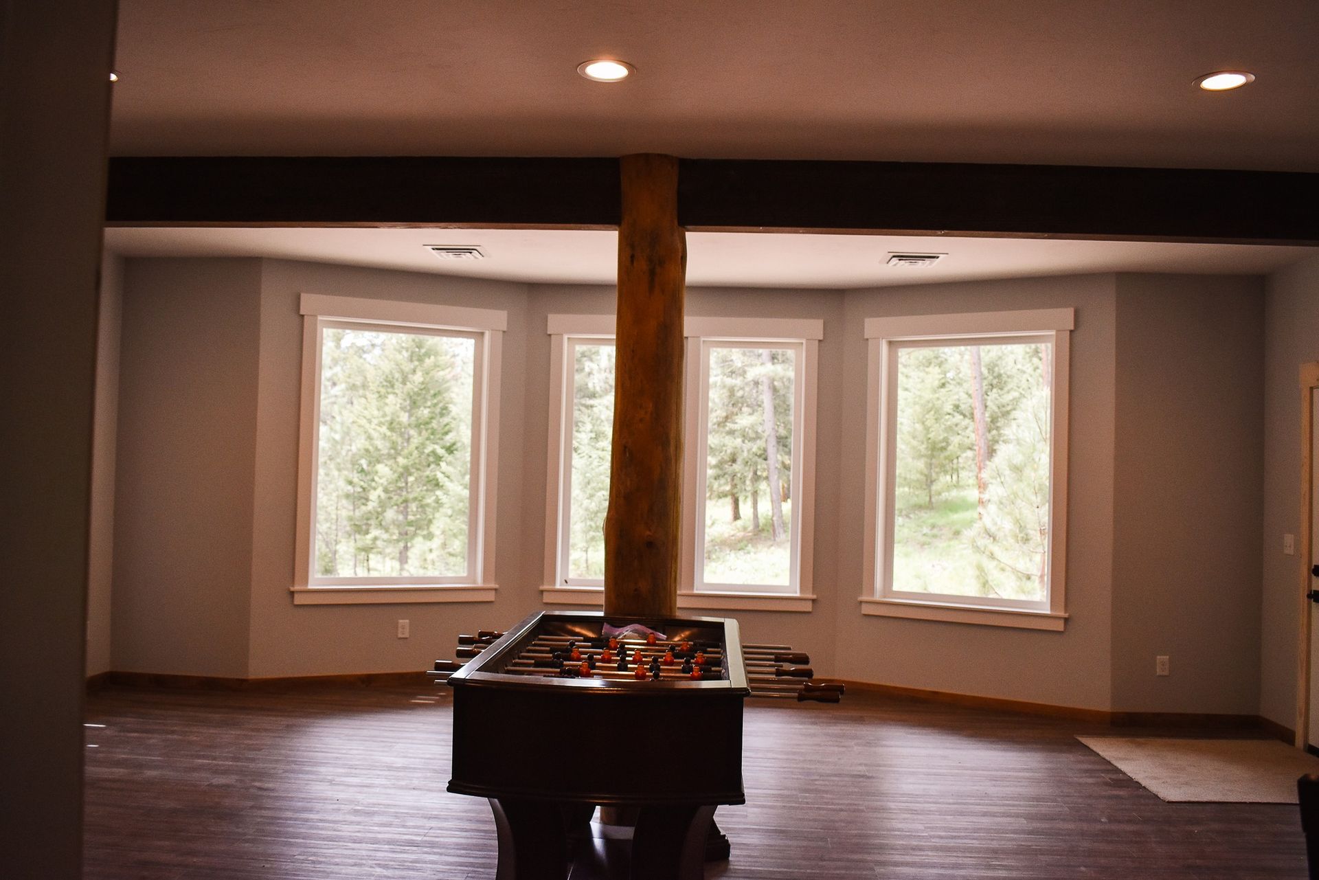 Empty room with a central table and large windows overlooking trees