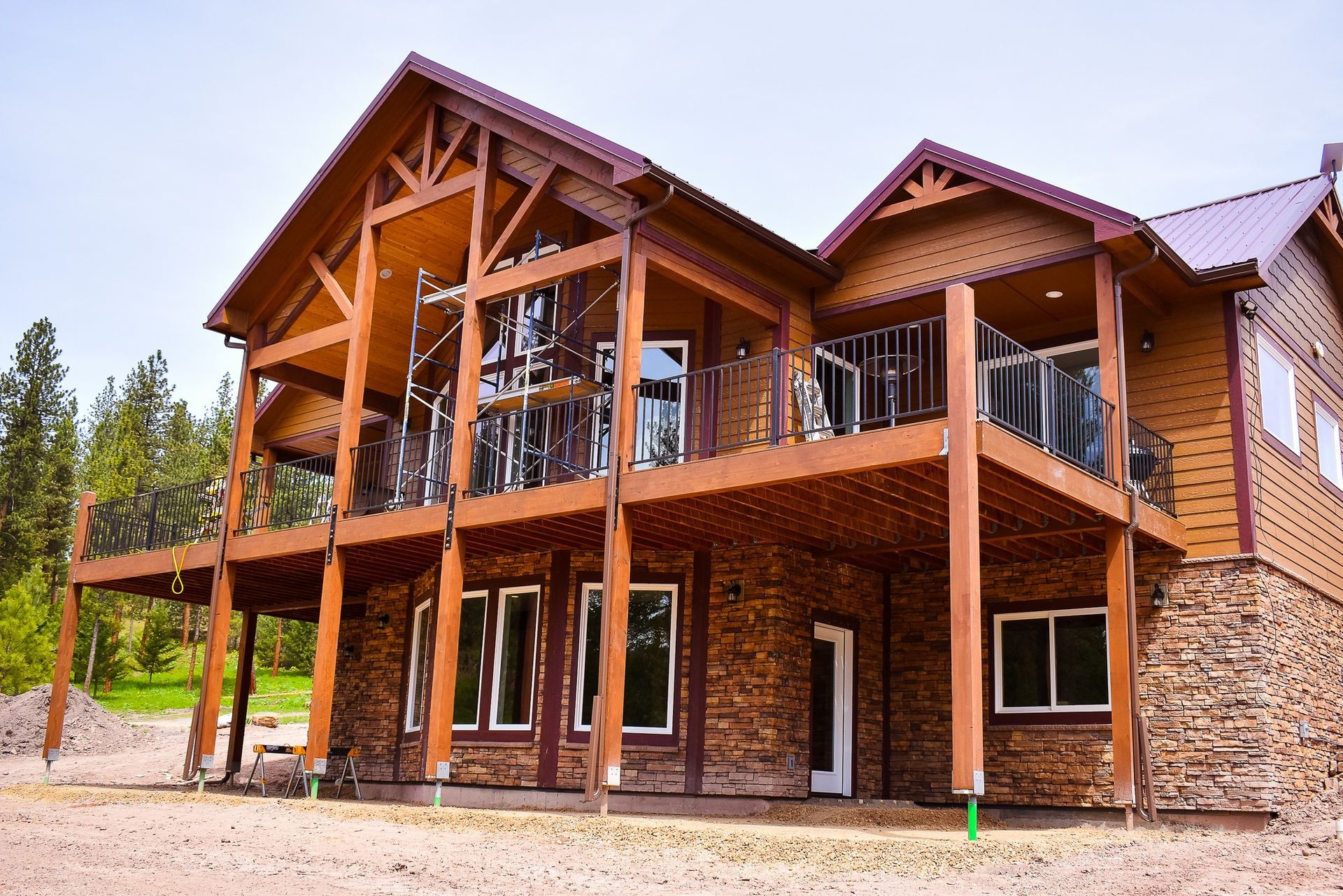 Large wooden house with stone accents and a covered porch, viewed from the front outdoors.