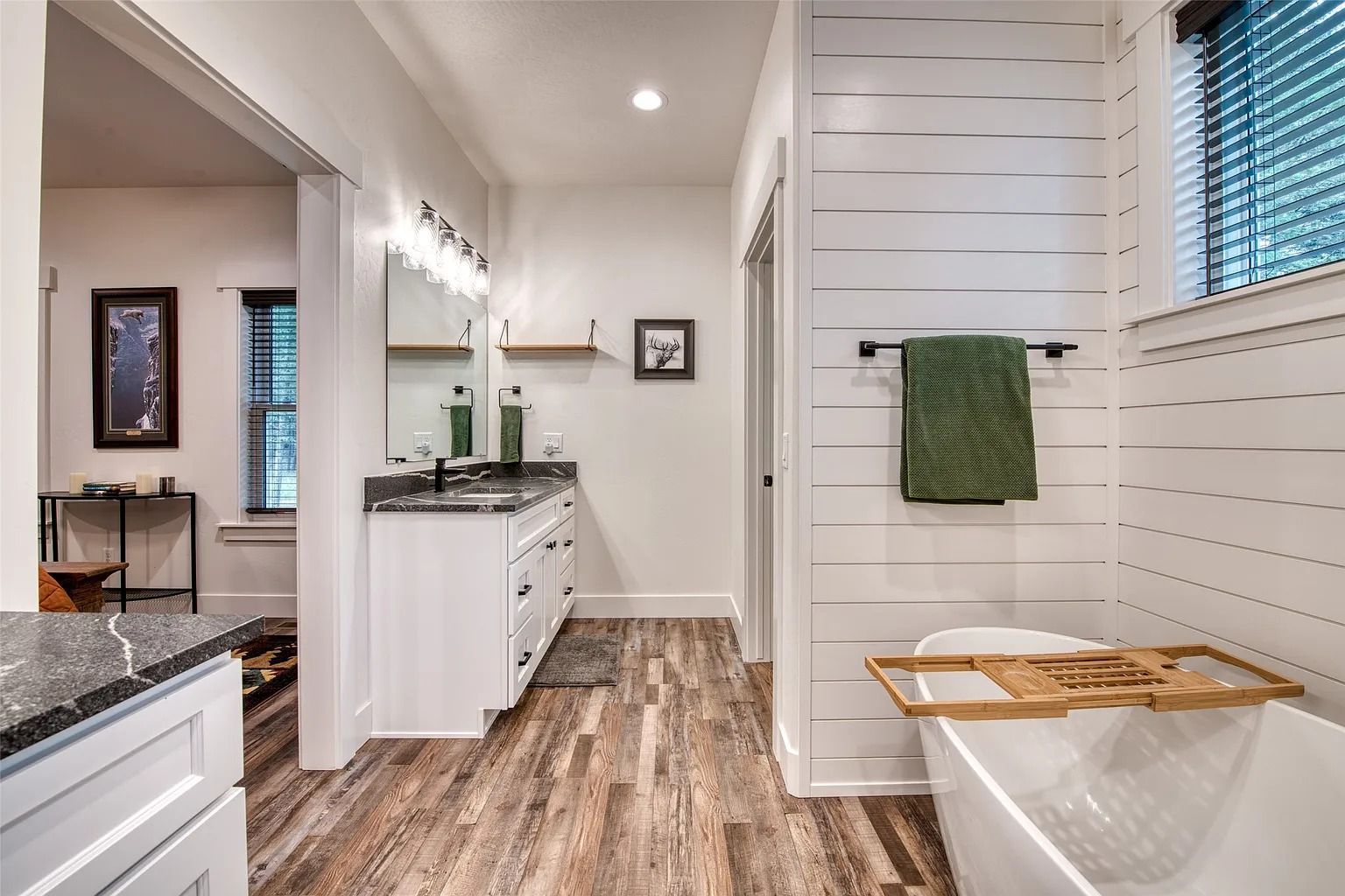 Bright modern kitchen with white cabinets, herringbone backsplash, island, and pendant lights