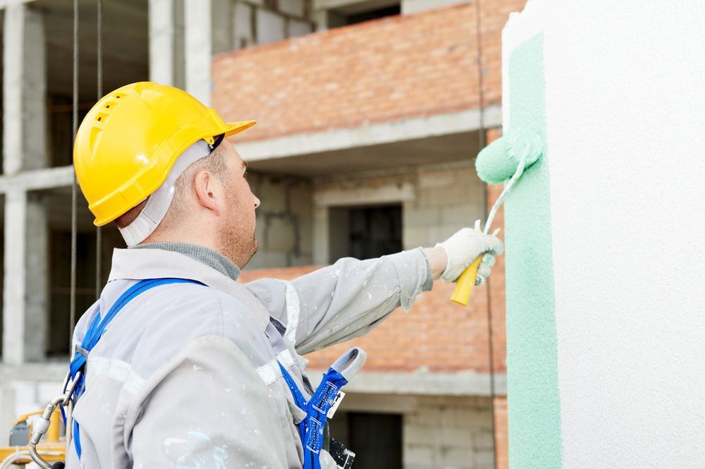 A Man is Painting a Wall With a Roller — Prota NT in Howard Springs, NT
