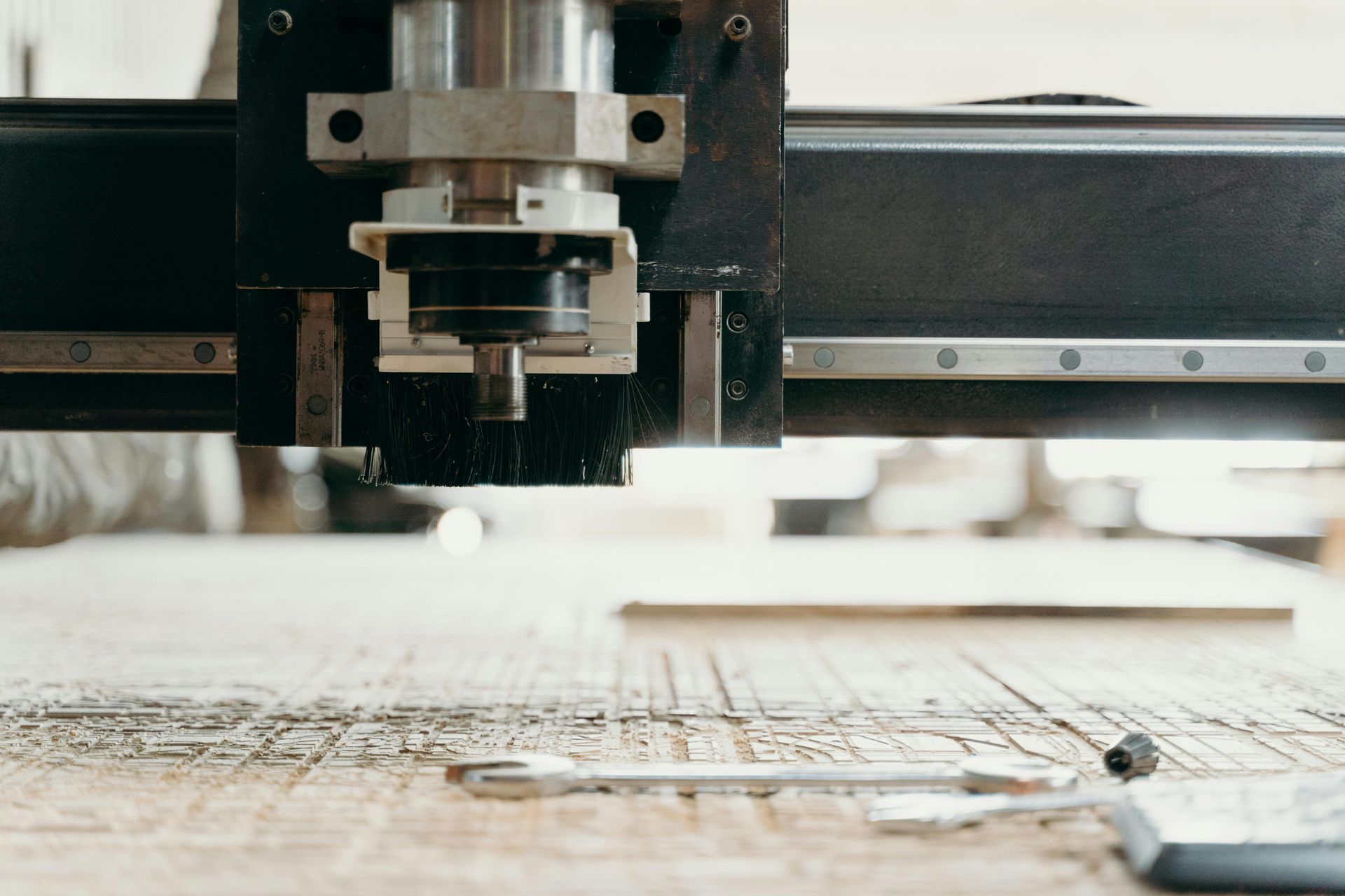 CNC machine cutting wood, sawdust visible.