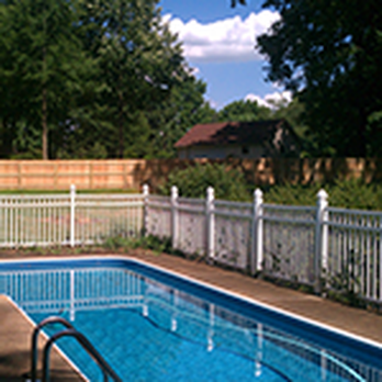A large swimming pool with a white fence around it