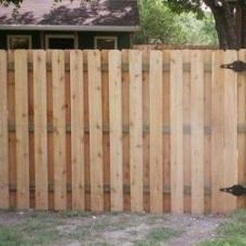 A wooden fence is sitting in front of a house.