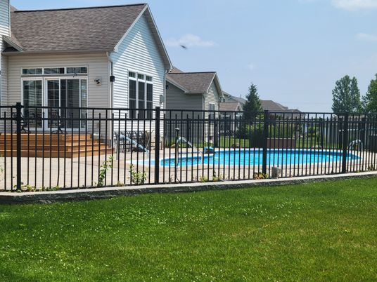 A house with a pool behind a metal fence