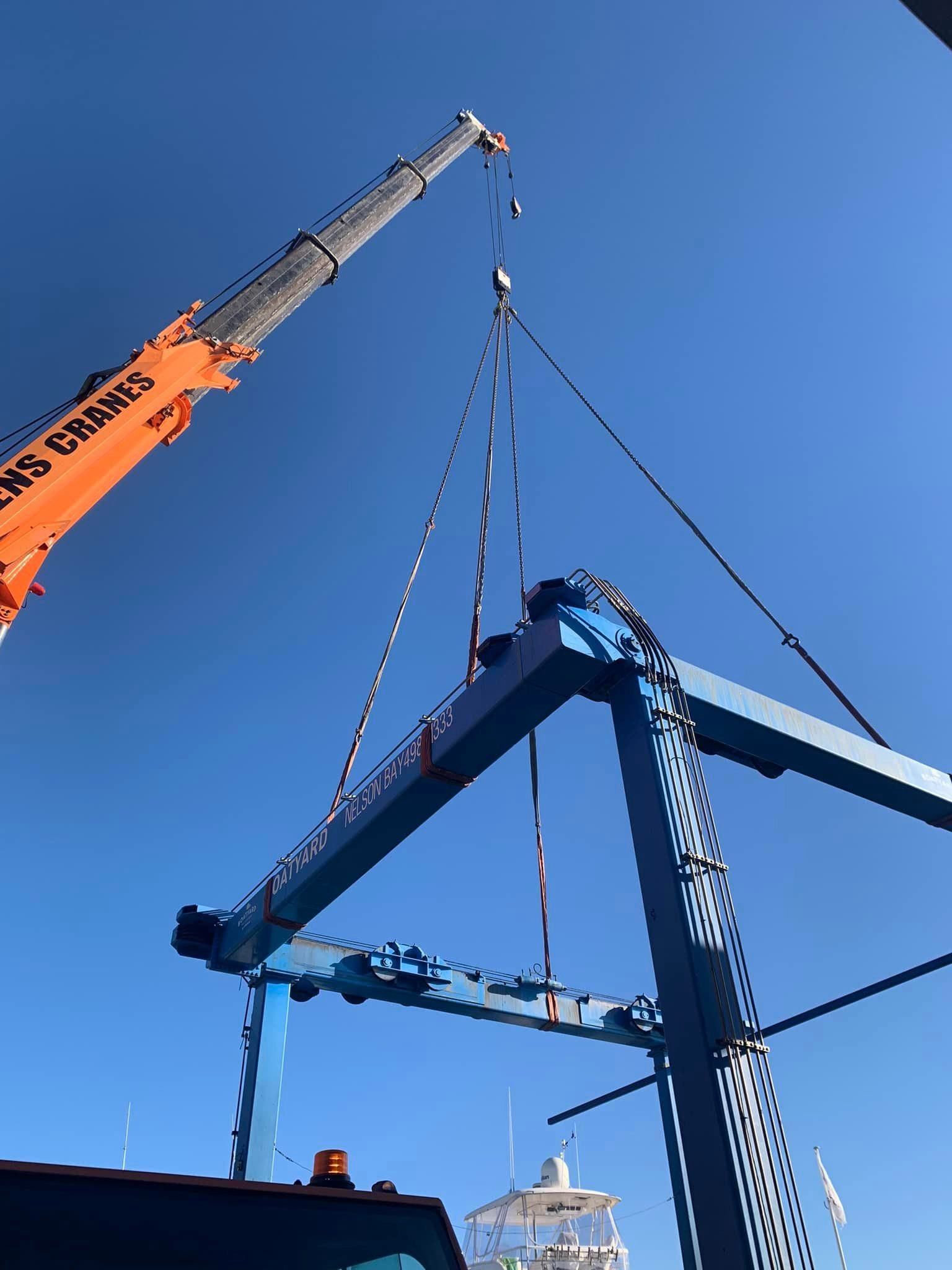 A Large Orange Crane Is Lifting A Large Piece Of Metal — Port Stephens Cranes In Salt Ash, NSW
