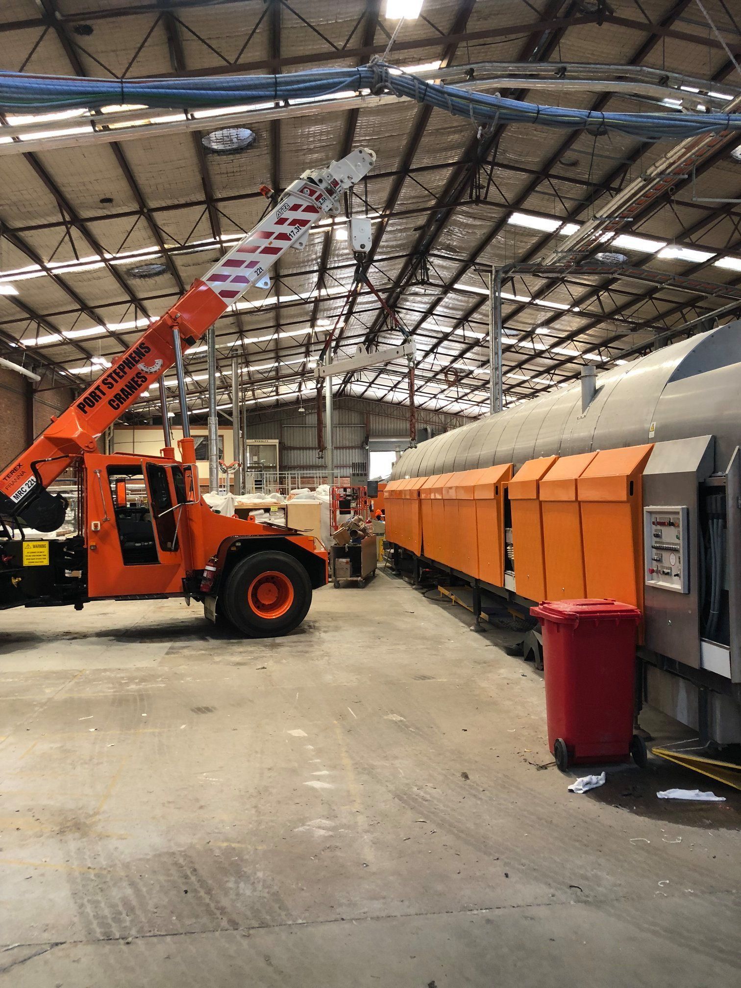 A Large Yellow Crane Is Demolishing A Building — Port Stephens Cranes In Maitland, NSW