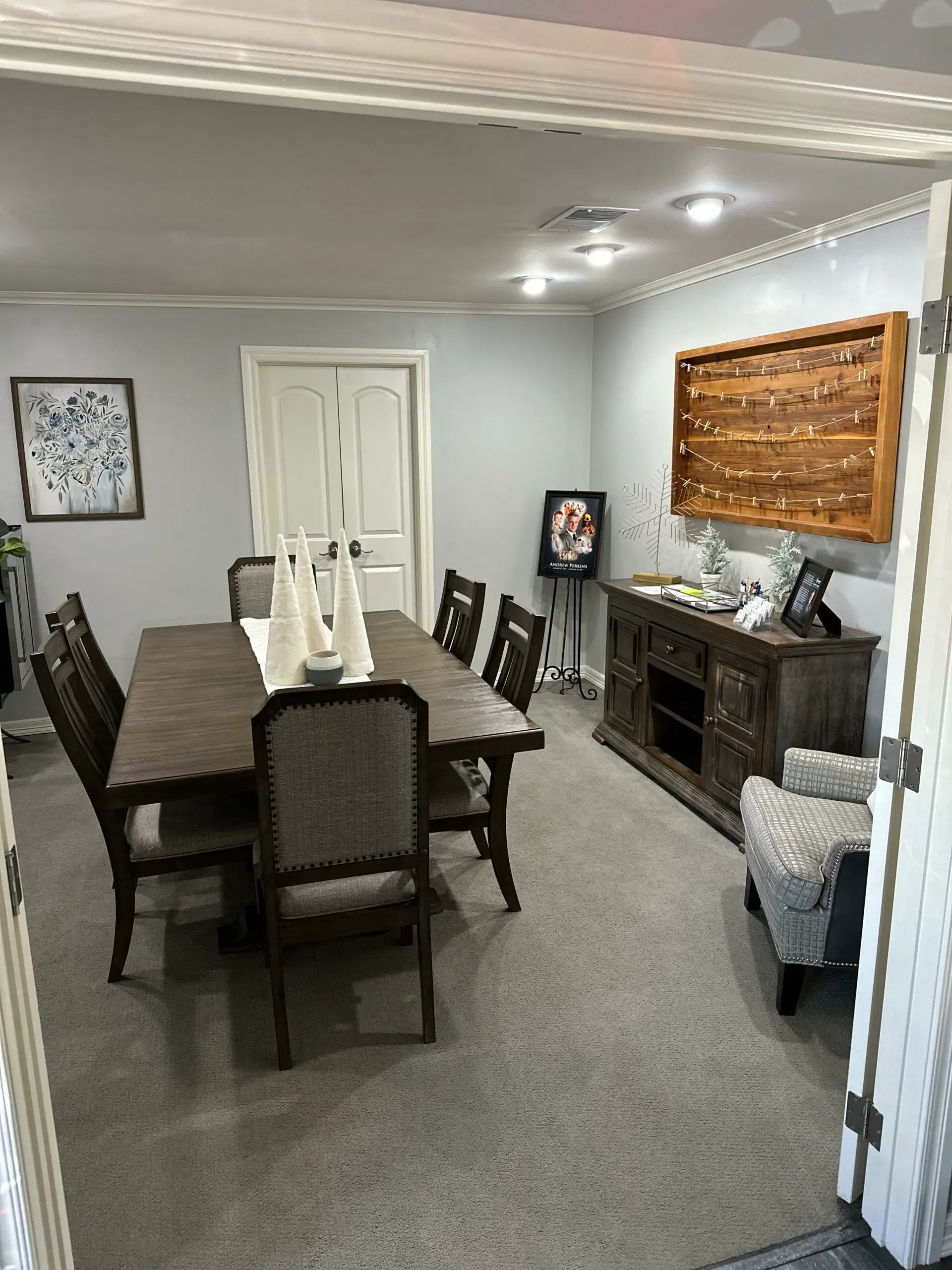 Dining room with dark wood table, six chairs, fireplace, and wall decor in a neutral-toned home