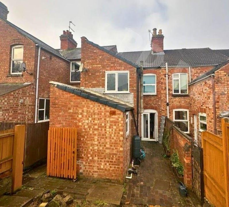 A brick building with a wooden fence in front of it