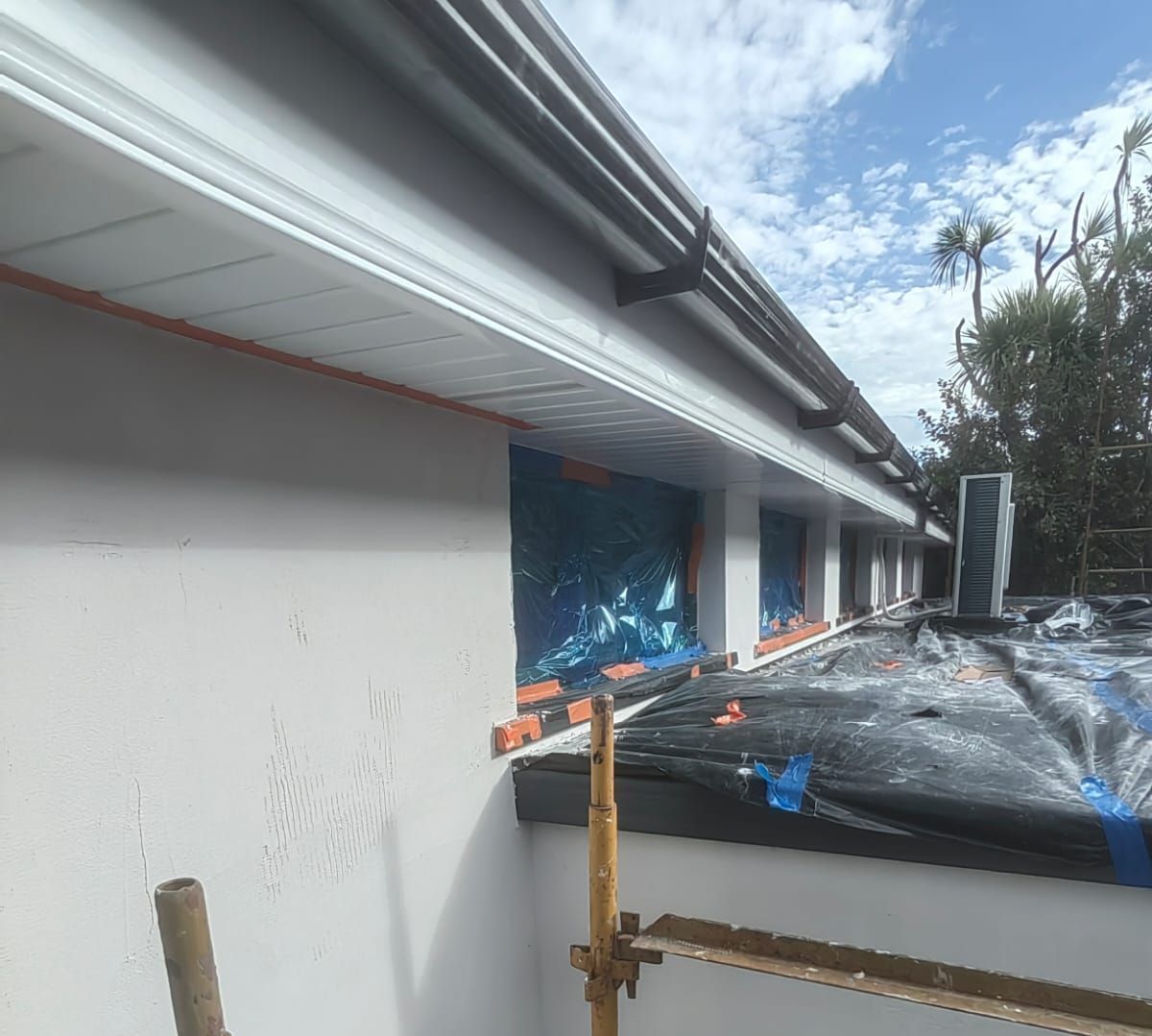 A gutter is being installed on the side of a building.