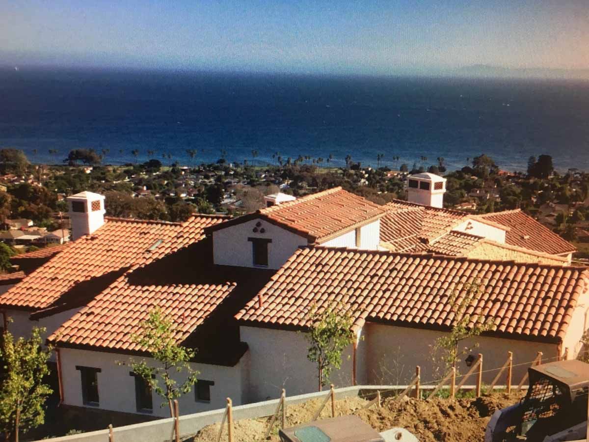 Sunlit coastal village with terracotta rooftops overlooking the blue ocean