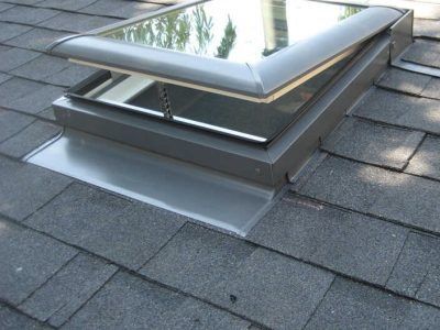 Open skylight on a gray shingled roof
