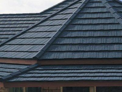 Dark gray shingled roof with intersecting ridges and a dormer skylight