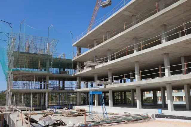 A large building is being built on a sunny day.