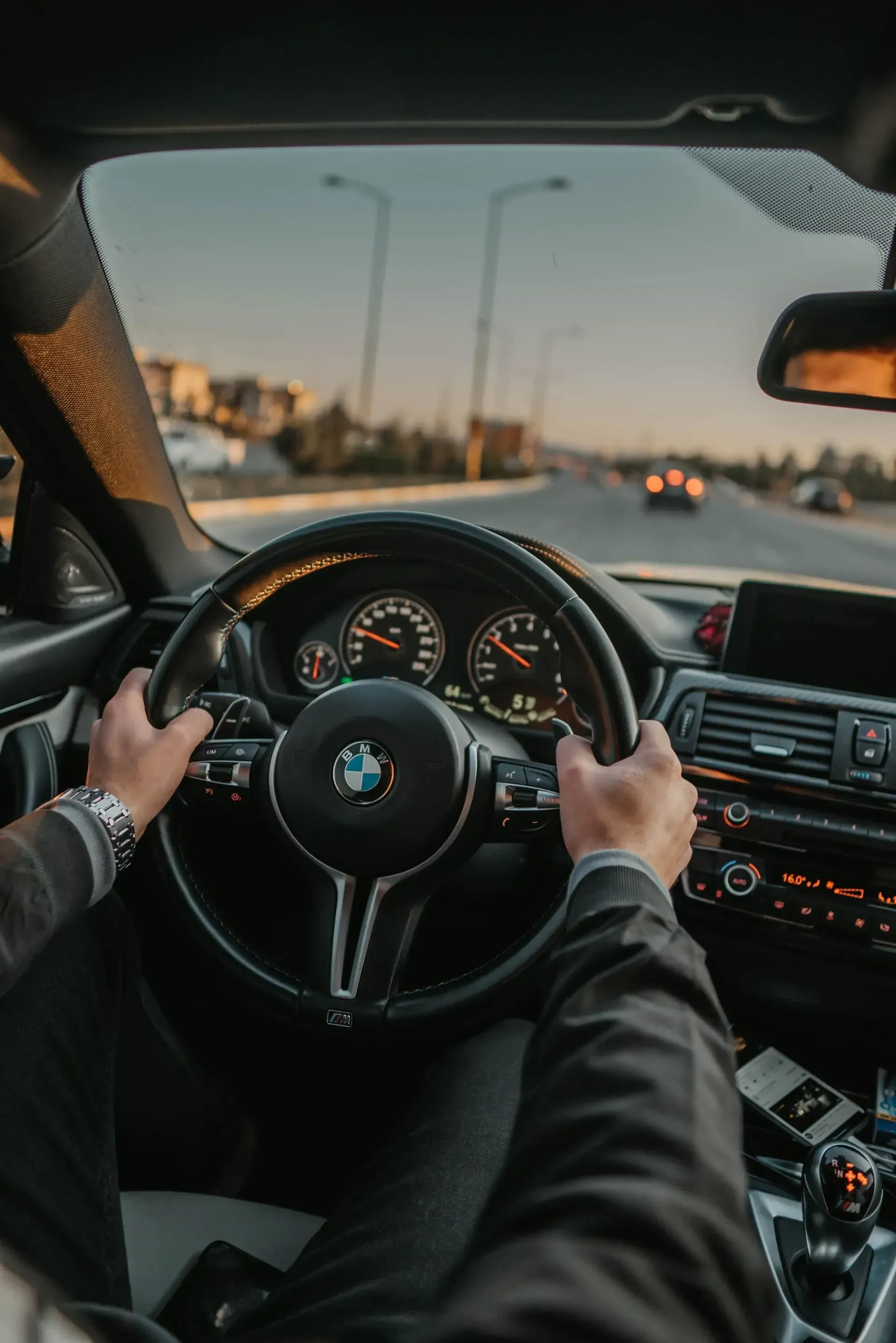 A man is driving a bmw on a highway.