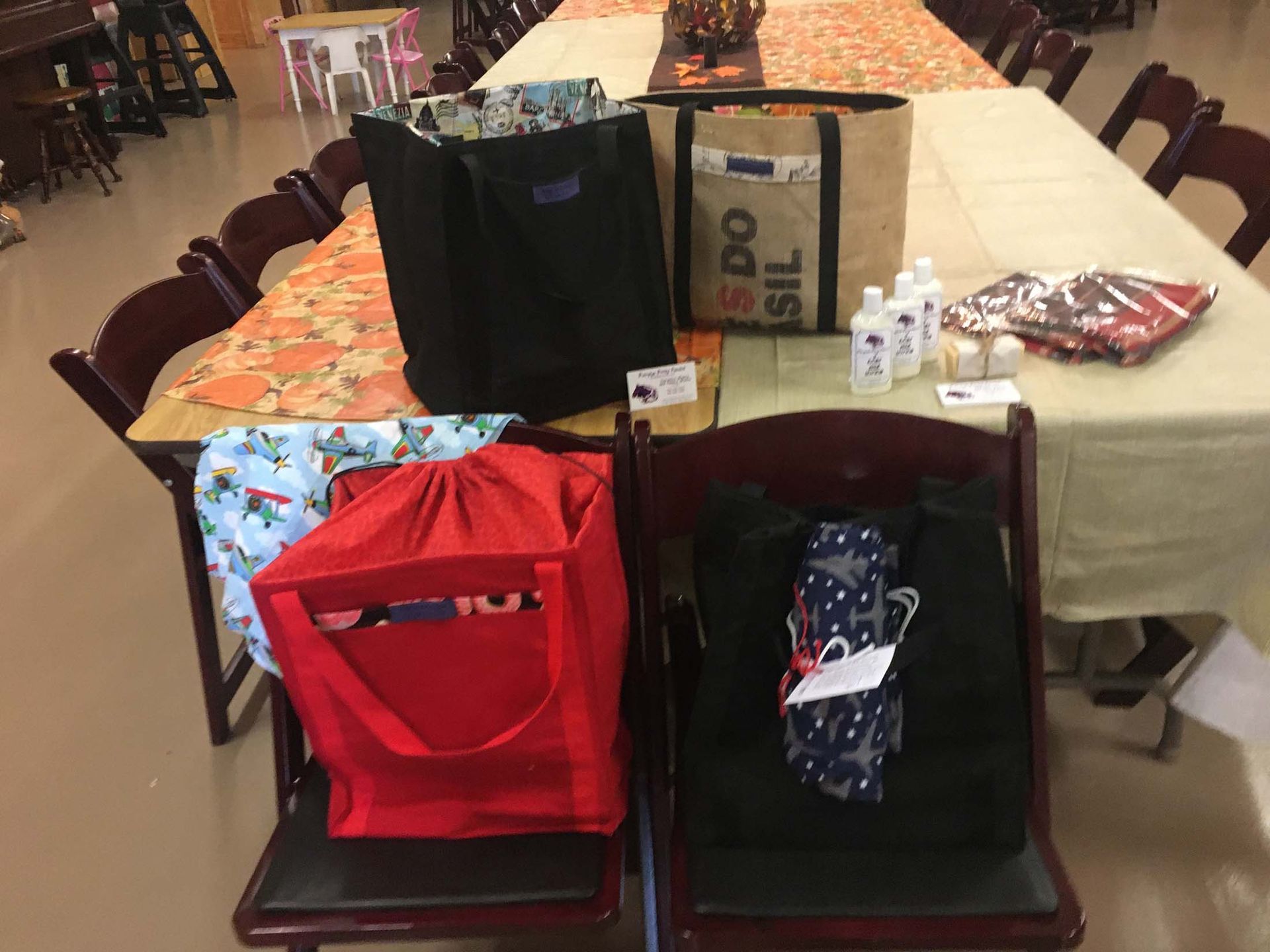 Two red and black gift bags on a long table in a dining room
