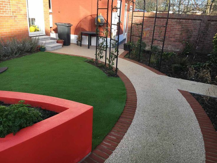 A garden in Chelmsford with a resin path and a red planter. Installed by Essex Resin driveways