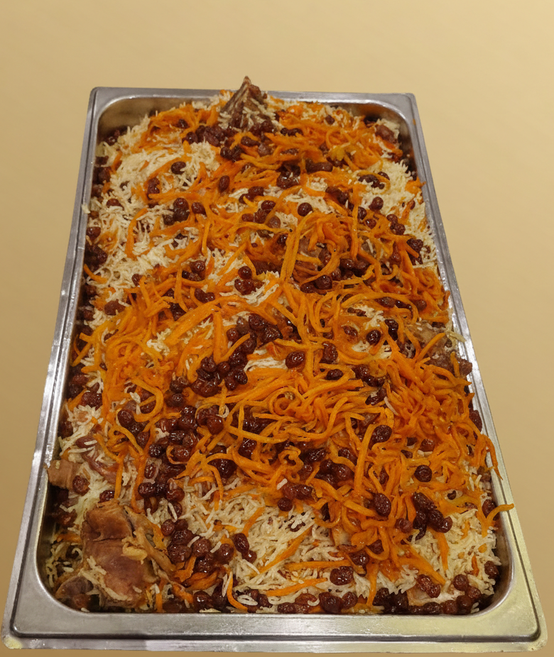 Stor rektangulär metallbricka med plov, en uzbekisk risrätt med morötter och russin.