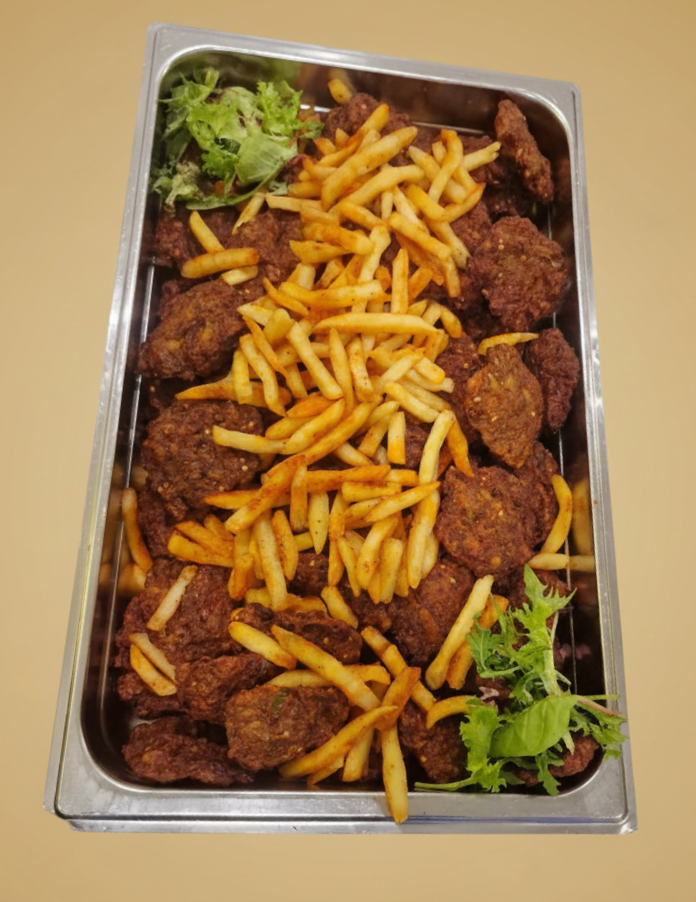 Bricka med friterad mat: kycklingbitar, pommes frites och grön garnering.