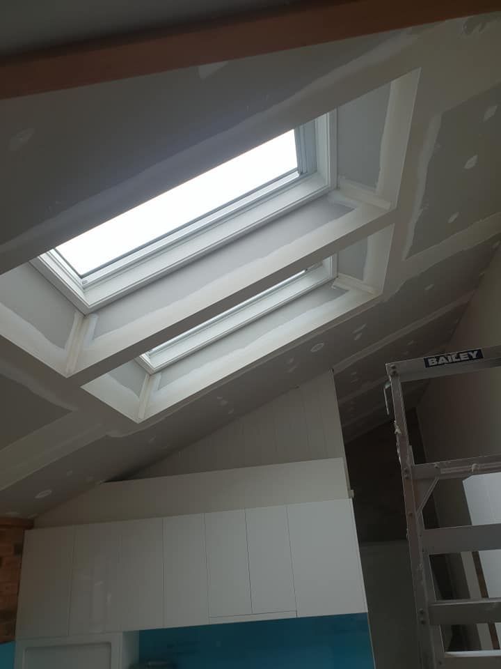 Skylight in a Sloped Ceiling Above White Cabinets and a Ladder — Damien Thompson Plastering King Creek, NSW