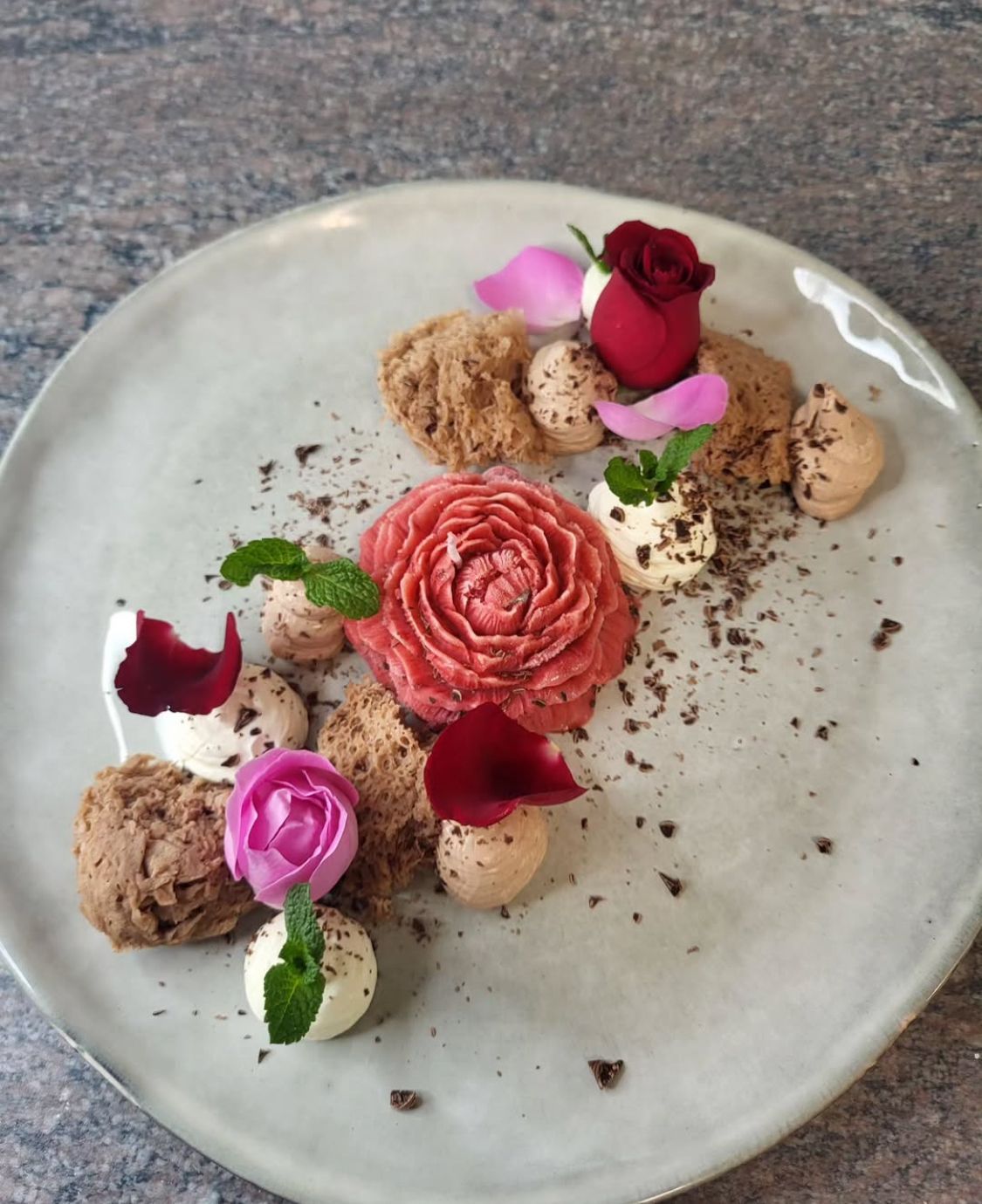 Une assiette de nourriture avec des fleurs et du chocolat dessus